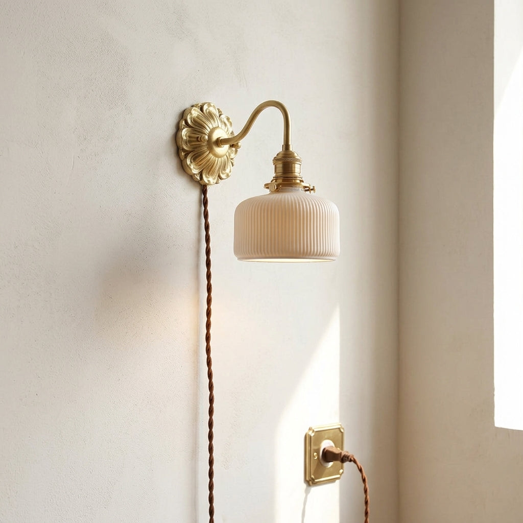 Wall-mounted lamp with gold fixture and beige lampshade on a light wall.